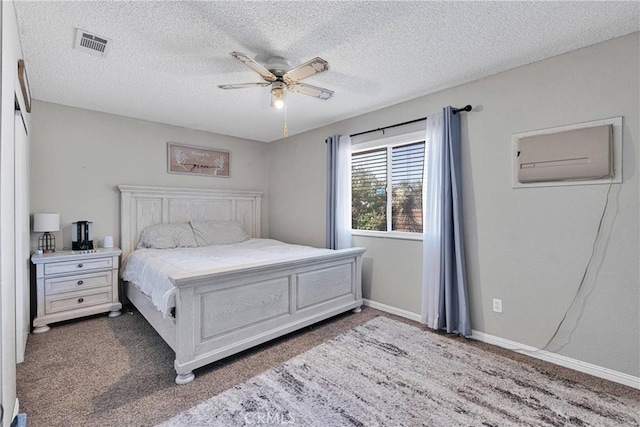 12546 Snapping Turtle Rd, Apple Valley, CA 92308 - carpeted bedroom featuring a textured ceiling, a wall mounted air conditioner, ceiling fan, and baseboards