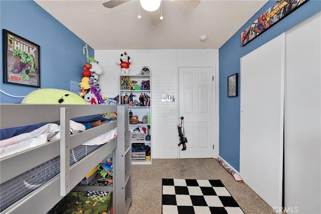 interior space featuring carpet, a ceiling fan, and a textured ceiling