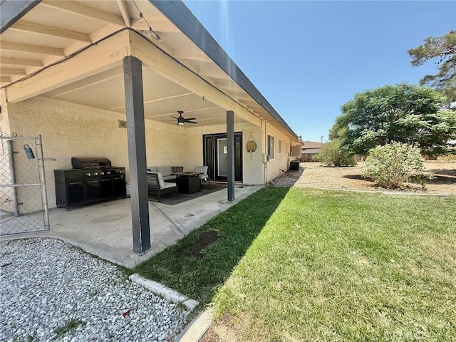 12546 Snapping Turtle Rd, Apple Valley, CA 92308 - back of property featuring ceiling fan, a lawn, stucco siding, an outdoor hangout area, and a patio area
