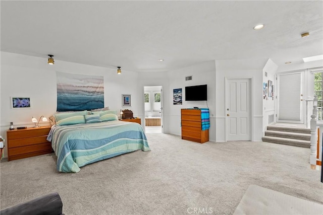 carpeted bedroom featuring recessed lighting, ensuite bath, and visible vents