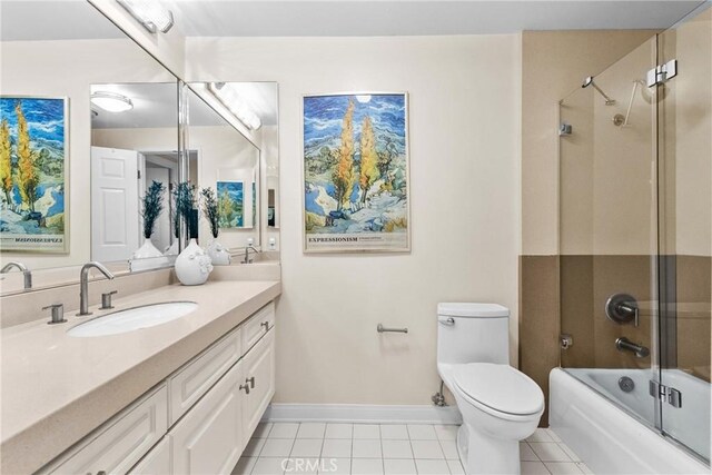 full bathroom with tile patterned flooring, vanity, toilet, baseboards, and combined bath / shower with glass door