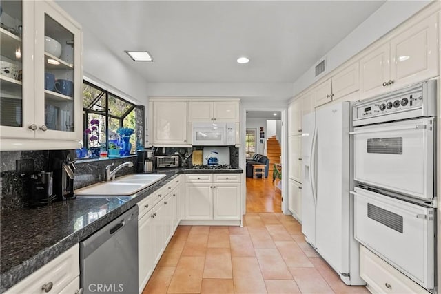 kitchen with visible vents, a sink, light tile patterned floors, recessed lighting, and white appliances