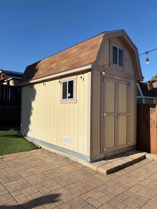 view of shed featuring fence