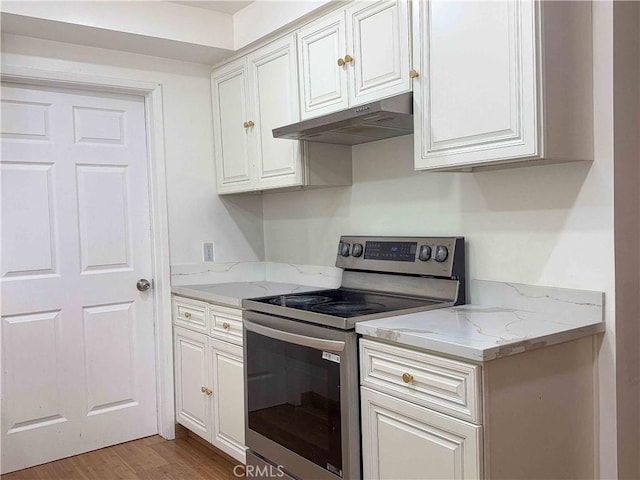 kitchen with stainless steel range with electric cooktop, light stone counters, white cabinets, light wood finished floors, and under cabinet range hood