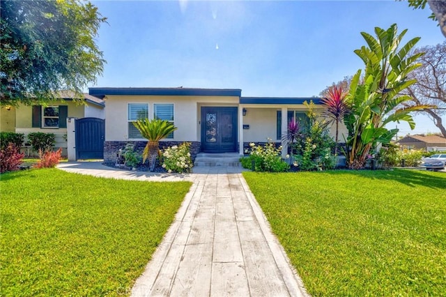 single story home featuring a gate, stucco siding, and a front lawn