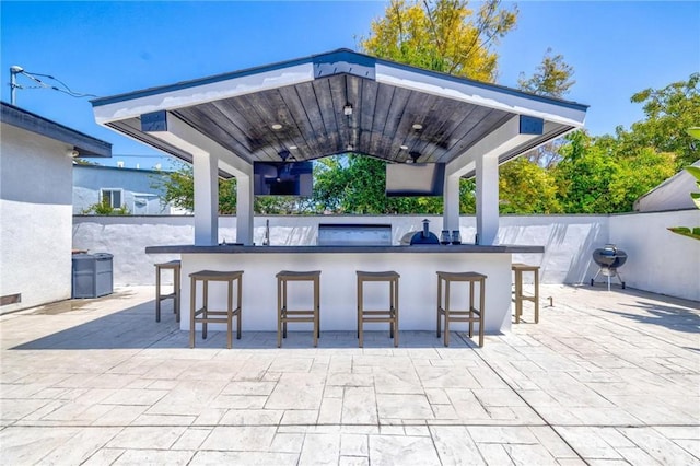 view of patio / terrace featuring a gazebo, fence, and outdoor wet bar