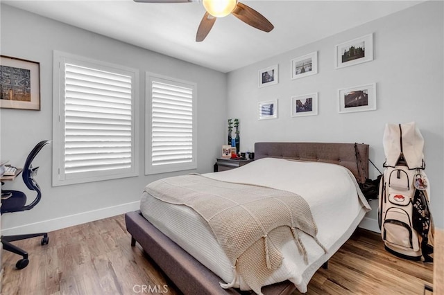 bedroom with baseboards, ceiling fan, and wood finished floors