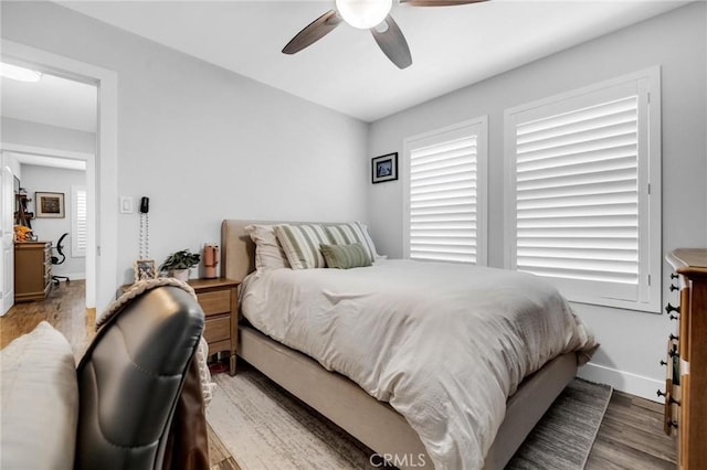 bedroom featuring baseboards, a ceiling fan, and wood finished floors