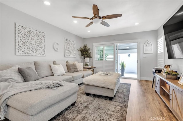 living room featuring recessed lighting, baseboards, ceiling fan, and light wood-type flooring