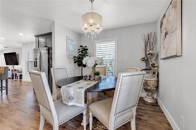 dining room featuring baseboards, recessed lighting, wood finished floors, and a notable chandelier
