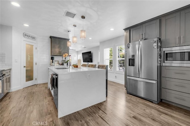 kitchen with a sink, appliances with stainless steel finishes, baseboards, and recessed lighting
