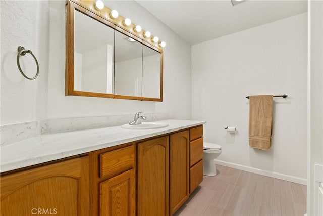 1489 Manzanita Ave, Chico, CA 95926 - bathroom with vanity, toilet, wood finished floors, and baseboards