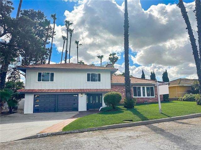 view of front facade featuring a tiled roof, concrete driveway, a front yard, and a garage