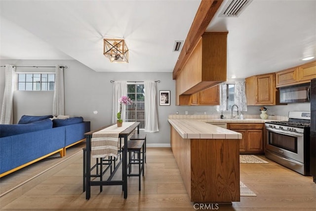 3241 Mills Ln, Crescenta, CA 91214 - kitchen with gas range, black microwave, tile countertops, and plenty of natural light
