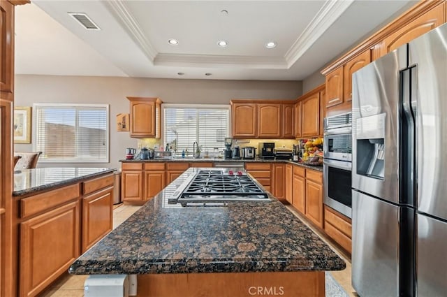 kitchen featuring visible vents, plenty of natural light, a center island, and stainless steel appliances
