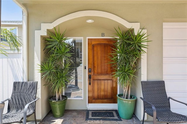 doorway to property featuring stucco siding