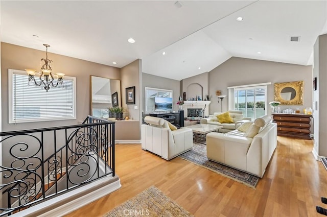 living room with an inviting chandelier, lofted ceiling, visible vents, and light wood-style floors