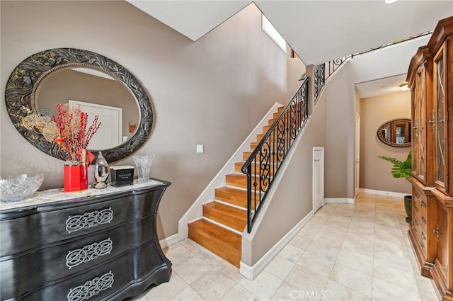 staircase featuring baseboards, tile patterned flooring, and a dry bar
