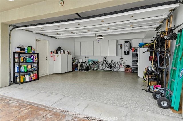 garage featuring a garage door opener and freestanding refrigerator