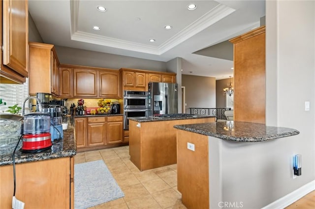 kitchen featuring appliances with stainless steel finishes, a center island, a raised ceiling, dark stone countertops, and recessed lighting
