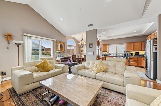 living room featuring an inviting chandelier, recessed lighting, light wood finished floors, and visible vents