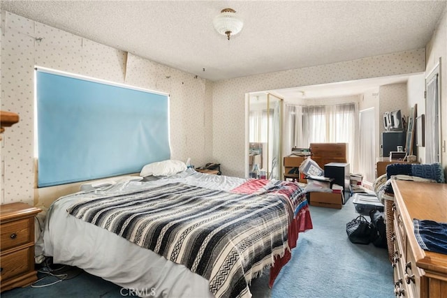 bedroom featuring carpet flooring, a textured ceiling, and wallpapered walls