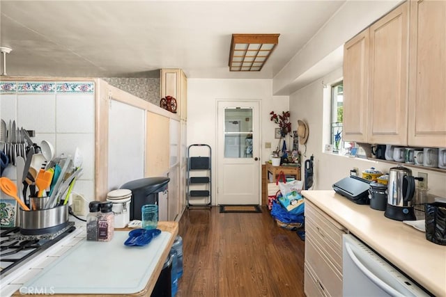 kitchen with light countertops, light brown cabinetry, dark wood finished floors, and dishwasher