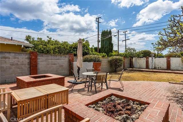 view of patio / terrace with a fenced backyard, outdoor dining space, and an outdoor fire pit