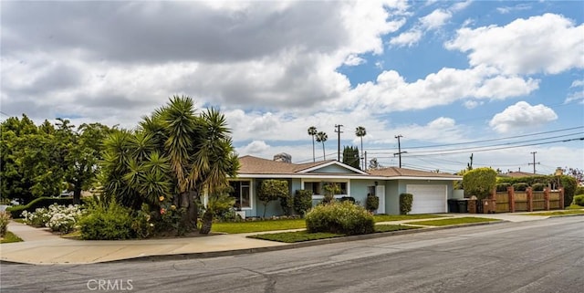 ranch-style home featuring an attached garage, fence, and driveway