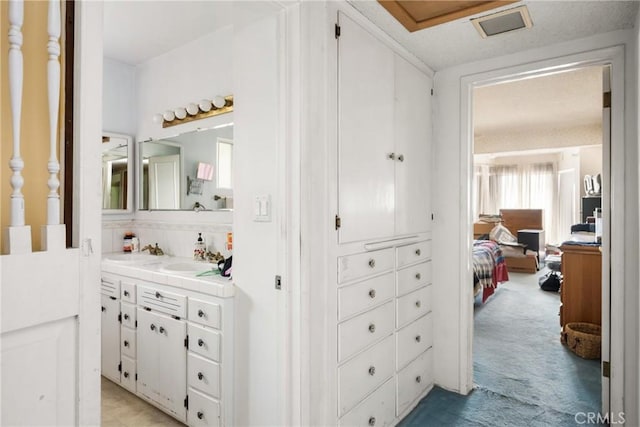 hall featuring a sink and light colored carpet