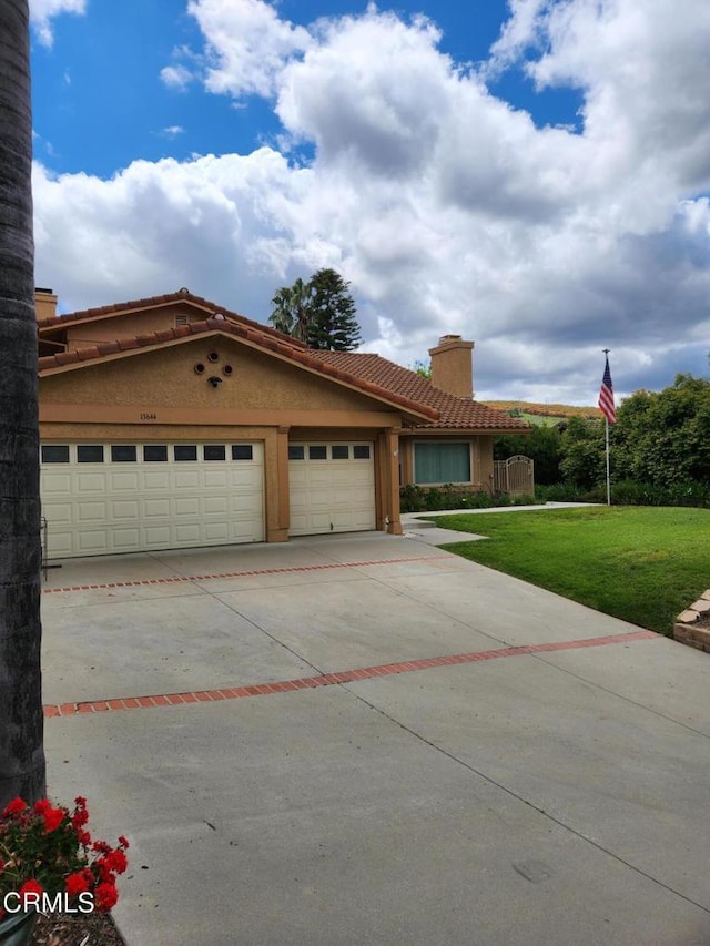 mediterranean / spanish home featuring a garage, a front lawn, a chimney, driveway, and a tile roof