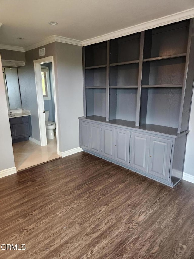interior space featuring baseboards, ornamental molding, dark wood-style flooring, and visible vents