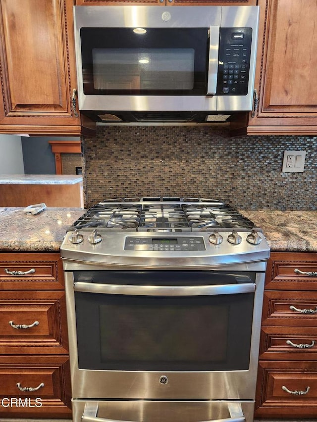 kitchen with brown cabinetry, decorative backsplash, and appliances with stainless steel finishes