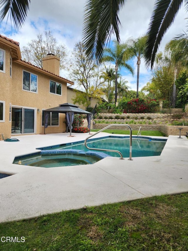 outdoor pool featuring an in ground hot tub, a gazebo, and a patio area