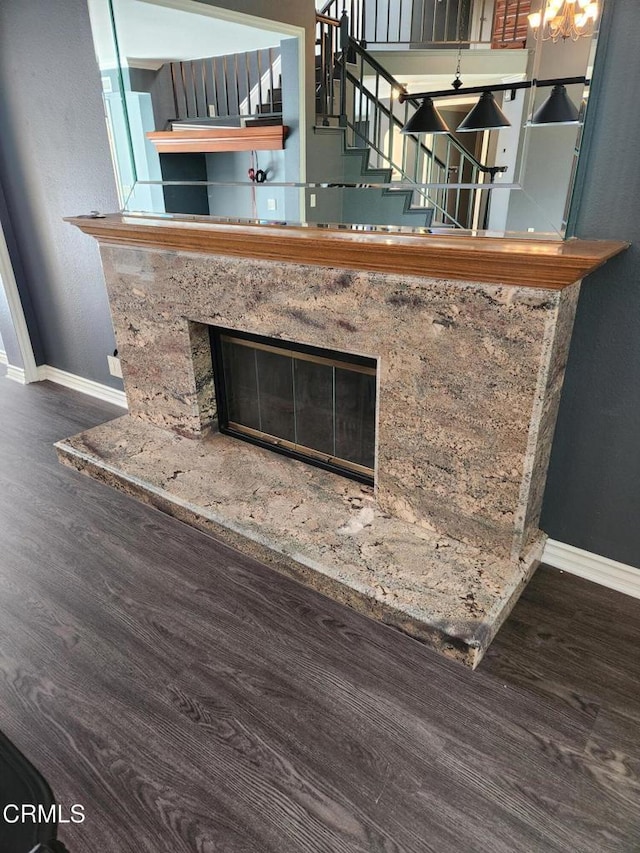 details with baseboards, wood finished floors, and a fireplace