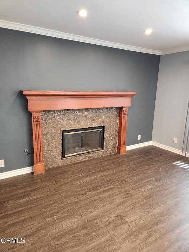 unfurnished living room featuring a high end fireplace, baseboards, and wood finished floors