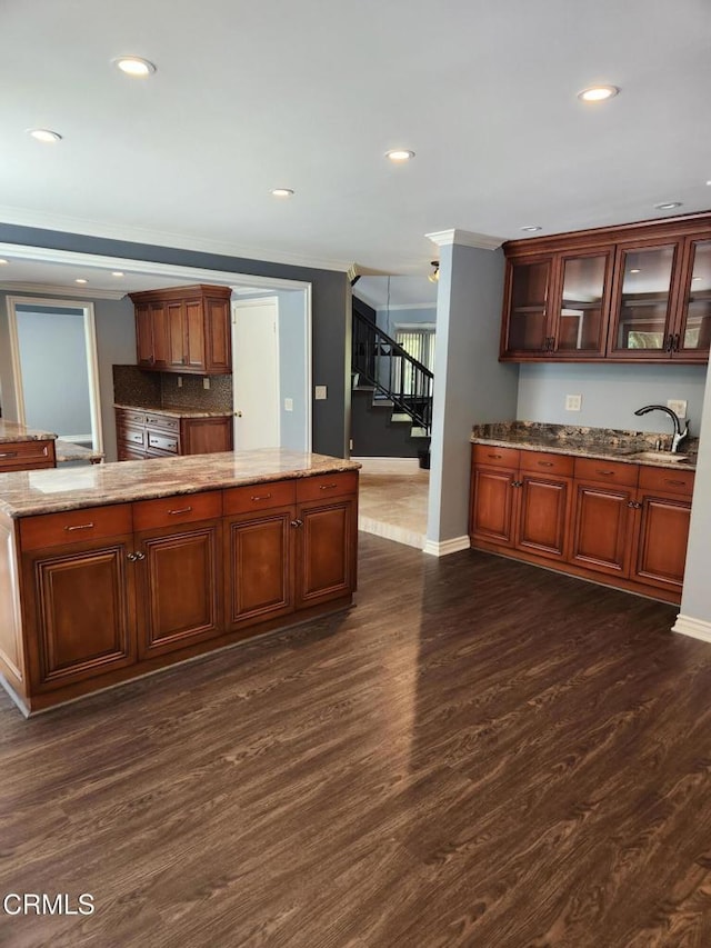 kitchen with a sink, baseboards, recessed lighting, and dark wood-style floors
