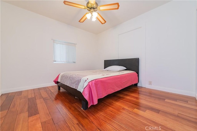 bedroom featuring a ceiling fan, baseboards, and hardwood / wood-style floors