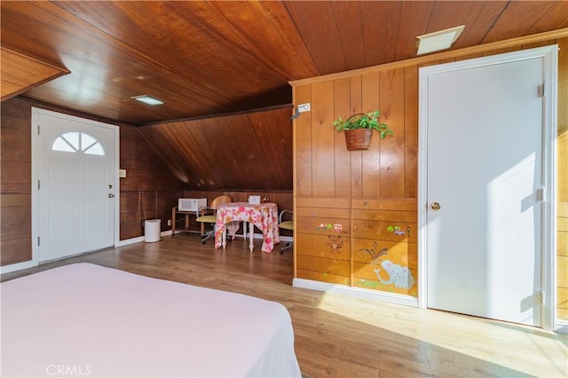 bedroom featuring wood walls, wood finished floors, vaulted ceiling, and wooden ceiling