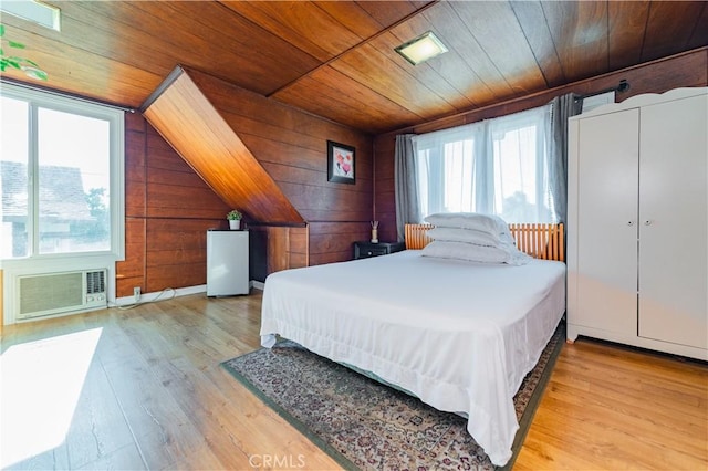 bedroom featuring wooden walls, wooden ceiling, a wall unit AC, and wood finished floors