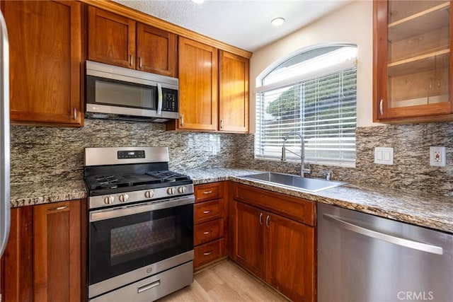 30902 Clubhouse Dr Unit 24E, Laguna Niguel, CA 92677 - kitchen featuring appliances with stainless steel finishes, tasteful backsplash, light wood-type flooring, brown cabinetry, and recessed lighting