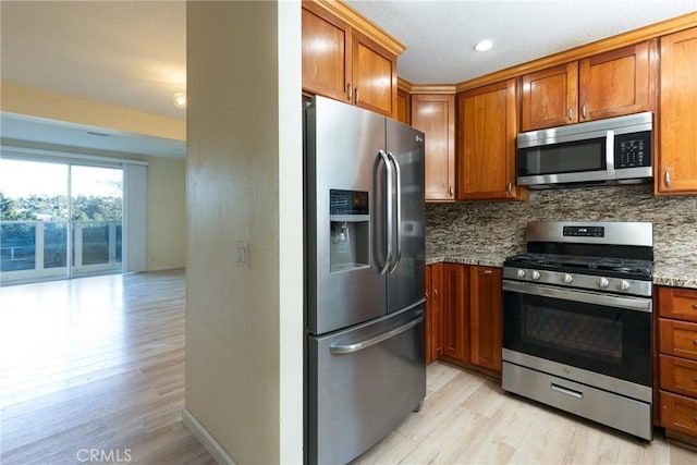 30902 Clubhouse Dr Unit 24E, Laguna Niguel, CA 92677 - kitchen with stainless steel appliances, tasteful backsplash, light wood-style flooring, brown cabinets, and recessed lighting