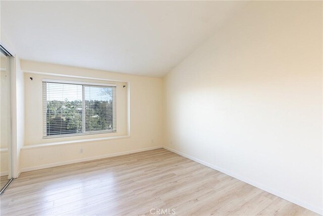 30902 Clubhouse Dr Unit 24E, Laguna Niguel, CA 92677 - spare room featuring light wood-style floors, baseboards, and vaulted ceiling