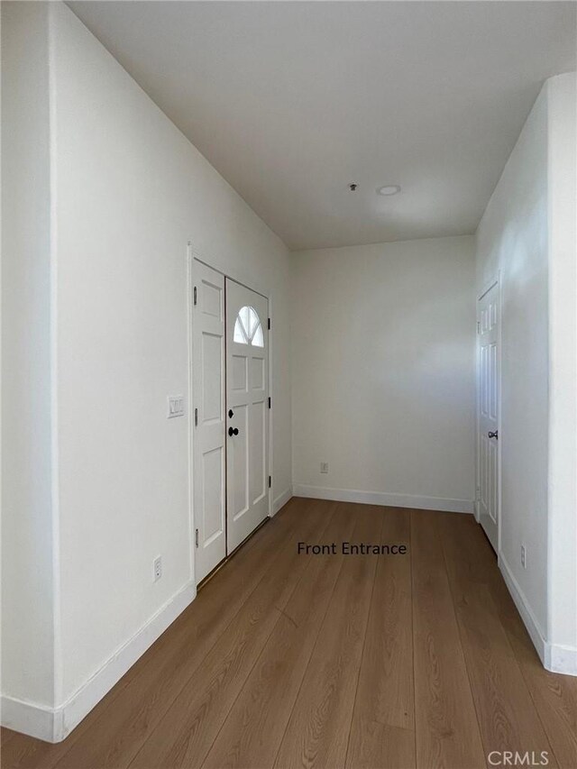 foyer entrance featuring baseboards and wood finished floors