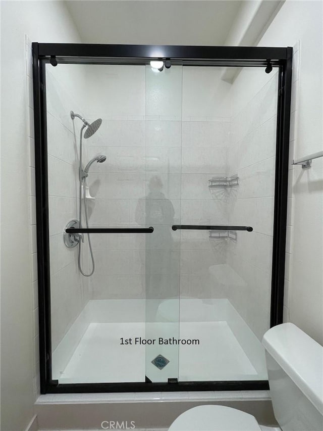 bathroom with toilet and a shower stall