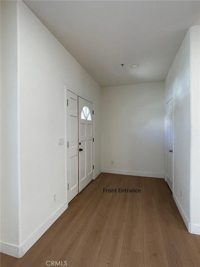 foyer entrance with baseboards and wood finished floors