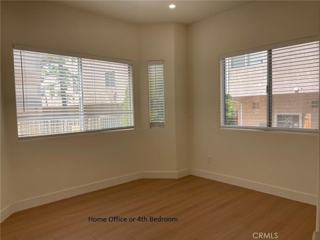 empty room with light wood-style floors, recessed lighting, baseboards, and a healthy amount of sunlight