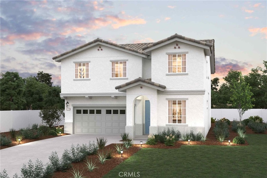 mediterranean / spanish-style house featuring a tile roof, fence, concrete driveway, an attached garage, and stucco siding