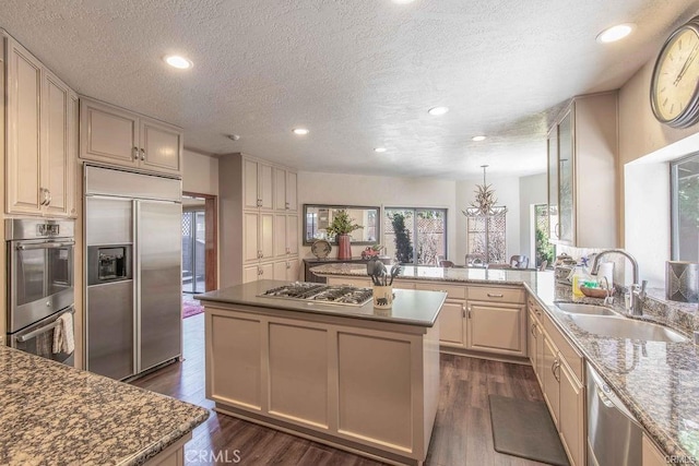 kitchen featuring a sink, a textured ceiling, appliances with stainless steel finishes, and a chandelier