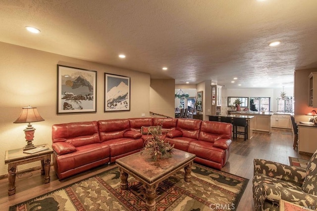 living area with recessed lighting, a textured ceiling, and dark wood-type flooring